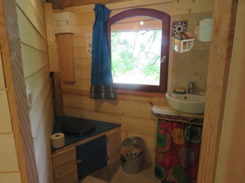 une petite salle de bain avec un lavabo et une fenêtre dans l'établissement kerterre, petit nid des petites Pyrénéees, à Sainte-Croix-de-Volvestre