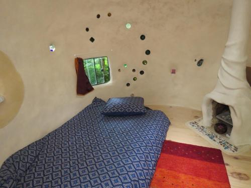 - une chambre avec un lit et un mur en pierre dans l'établissement kerterre, petit nid des petites Pyrénéees, à Sainte-Croix-de-Volvestre