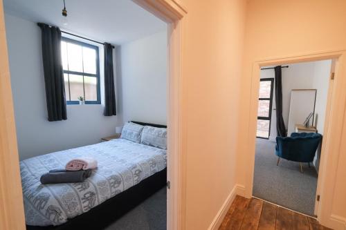 a bedroom with a bed and a window at The Eden Warehouse - Pink Apartment (sleeps 4) in Southport
