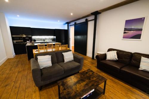 uma sala de estar com dois sofás e uma mesa de centro em The Eden Warehouse - Pink Apartment (sleeps 4) em Southport