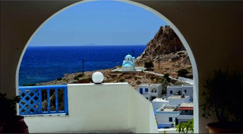 an archway view of the ocean from a building at Arhontiko Hotel in Foinikion