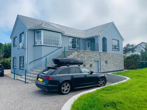 a car parked in front of a blue house at The Lake House Dungloe in Dungloe