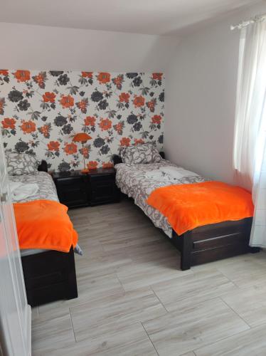 una camera con 2 letti e lenzuola arancioni di Savana a Gołubie