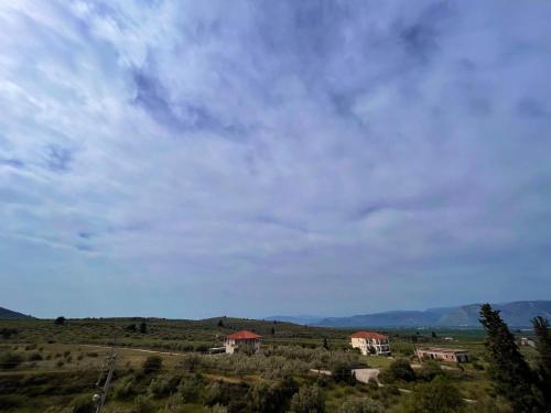 a group of houses on a hill with a cloudy sky at La Petite Planete in Mykines