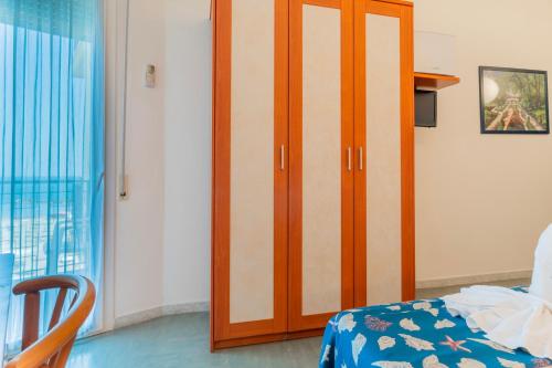 a wooden door in a room with a bed at Hotel Montmartre in Rimini