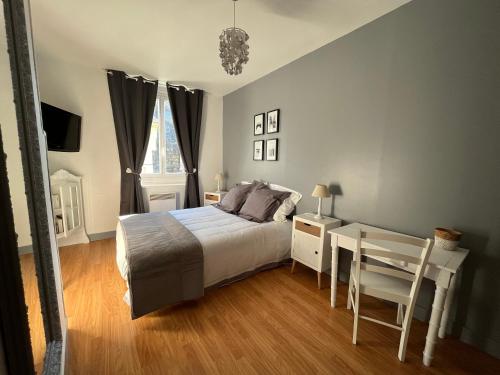 1 dormitorio con cama, mesa y ventana en Le Gîte du Petit Buccin à 2 mn de la mer. en Dieppe