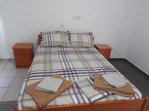 1 cama con 2 almohadas y toallas en ARIADNIS 3 BEDs apt, en Pomos