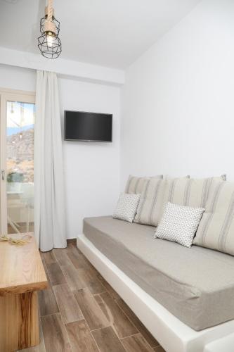 a white room with a bed and a table at GRΕΛΙΑ ΗΟΜΕ in Naxos Chora