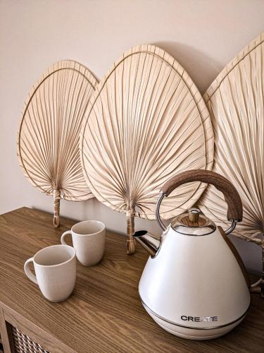 une bouilloire et deux tasses sur une table dans l'établissement Lodge coocon & SPA, à Nîmes