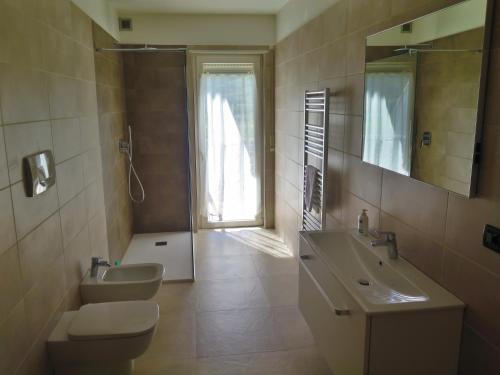 a bathroom with a sink and a toilet and a mirror at Bed and Breakfast La Cesura in Mattarello