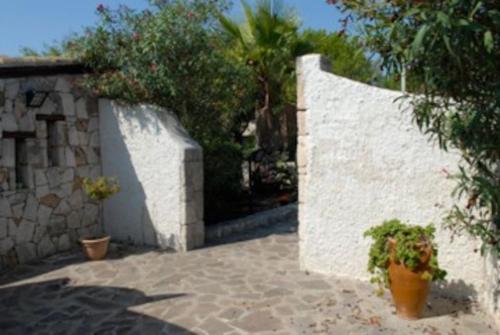 a white wall with two potted plants next to it at Villa Sebastian- Incomparabile vista sul mare in Siracusa