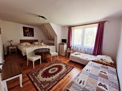 a bedroom with two beds and a table at Willa Pod Piórem in Zakopane