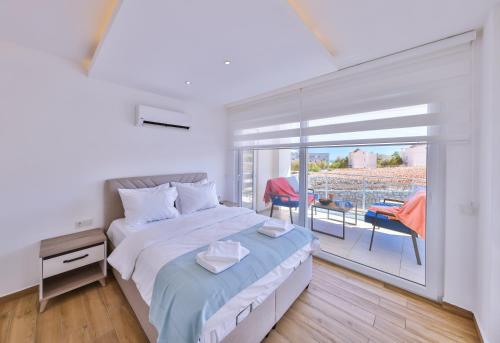 - une chambre blanche avec un lit et un balcon dans l'établissement Olive View Penthouse, à Kalkan