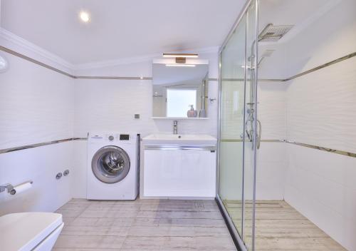 a bathroom with a washing machine and a sink at Olive View Penthouse in Kalkan