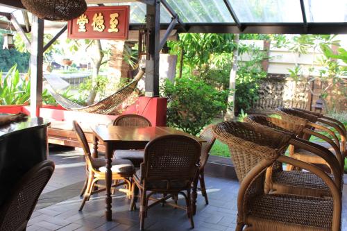 a restaurant with chairs and a table and a hammock at The Riverside Guest House in Lampang