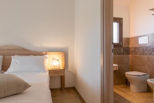 a bedroom with a bed and a toilet and a sink at MARISTESI in Siniscola