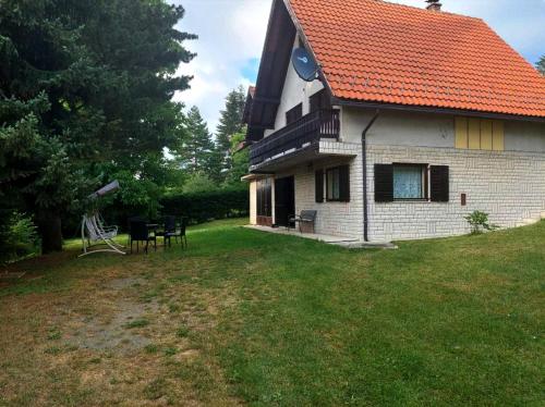 a house with an orange roof on a yard at Kuca za odmor Zlatibor in Zlatibor