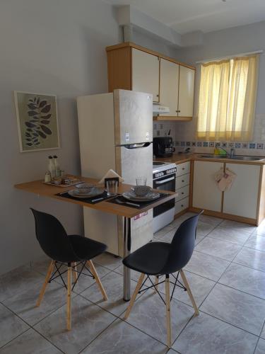 una cocina con mesa y 2 sillas. en Apartment by the sea in Xilokastro, en Xylokastro