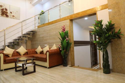 a living room with a couch and a staircase at Hotel Pearl in Navi Mumbai