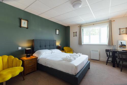 a bedroom with a bed and a table and chairs at The Imperial Dragon Hotel in Saundersfoot