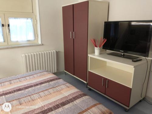 a bedroom with a tv and a dresser with a bed at IDA S Apartament in Pontecagnano