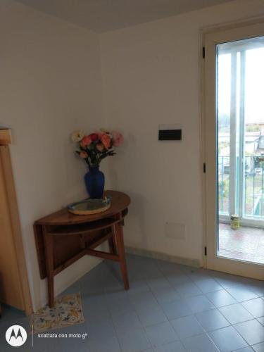 a room with a table with a vase of flowers on it at IDA S Apartament in Pontecagnano