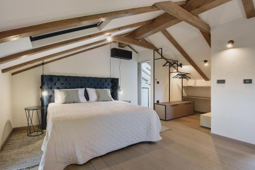 a bedroom with a large bed in a room with wooden ceilings at Casa Evina in Krnica