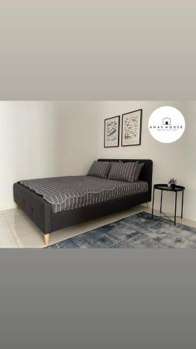 a black bed in a room with a white wall at Anas House in Tanjung Rambutan