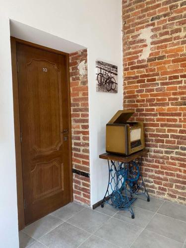 un microondas sentado en un puesto junto a una pared de ladrillo en Hotel Rover, en Leópolis