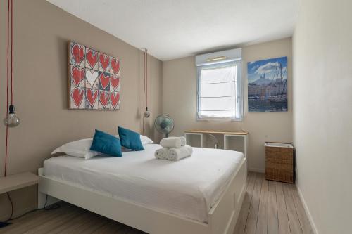 SIROCCO - Bel appartement avec extérieur proche des plages في مارسيليا: غرفة نوم مع سرير أبيض كبير مع وسائد زرقاء