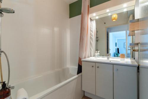 a bathroom with a tub and a sink and a mirror at SIROCCO - Bel appartement avec extérieur proche des plages in Marseille