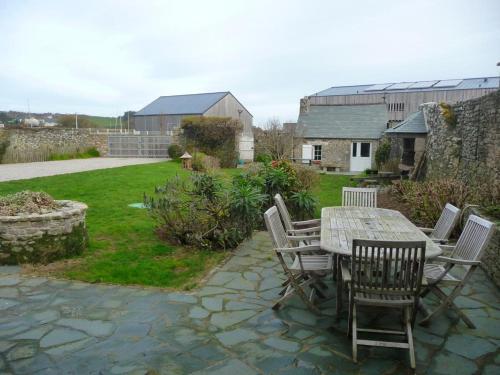 a patio with a table and chairs in a yard at GITE DU HABLE in Omonville-la-Rogue