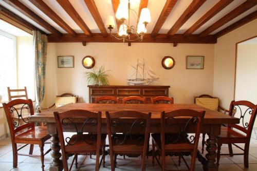 a dining room with a wooden table and chairs at GITE DU HABLE in Omonville-la-Rogue