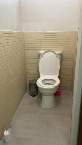 een badkamer met een wit toilet in een stal bij Colonial cocoon studio in La Gaulette