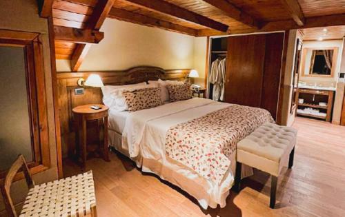 a bedroom with a bed in a room with wooden ceilings at Dos Bahias Lake Resort in Villa La Angostura