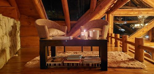 a table in a cabin with chairs and books at Dos Bahias Lake Resort in Villa La Angostura