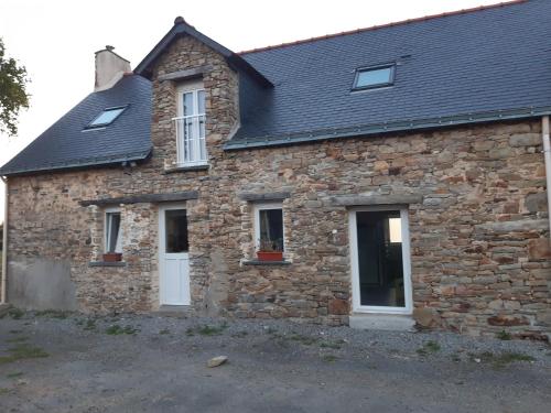 an old stone house with a black roof at gîte « Chez Albertine et Thérèse » in Ruffigné