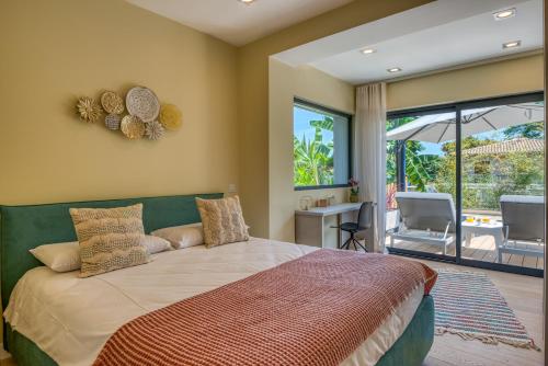 a bedroom with a large bed and a patio at Deluxe VILLA GRAZIELLA 200 M FROM THE BEACH in Èze