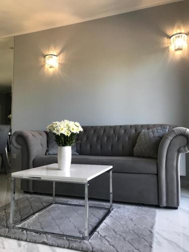 a living room with a couch and a coffee table at Unique Baltic Apartments - Apartament z garażem in Kołobrzeg