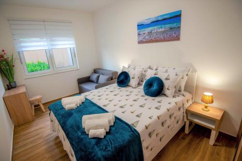 een slaapkamer met een groot bed met blauwe kussens bij My Adriatic Suite with private garden in Šibenik