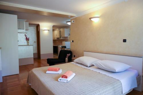 a bedroom with a bed with two towels on it at Apartments Okuka in Split