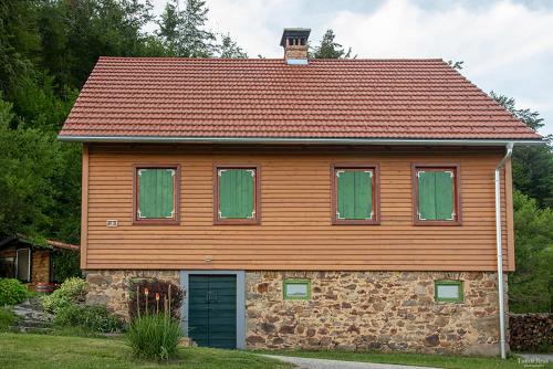 a wooden house with green windows and a roof at Kuća za odmor ''Julka'' in Plešce