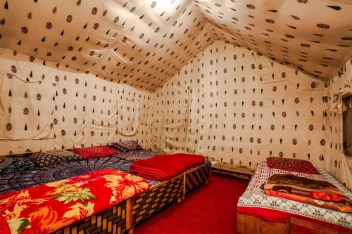 1 dormitorio con 2 camas en una habitación con pared en Odyssey Stays Parvati Woods Camps, en Kasol