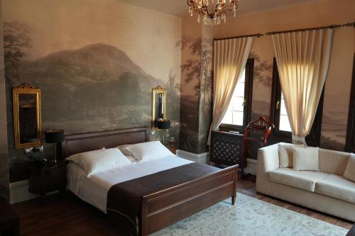 a bedroom with a bed and a couch and a chandelier at Hotel Boutique Vila 8 in Durrës