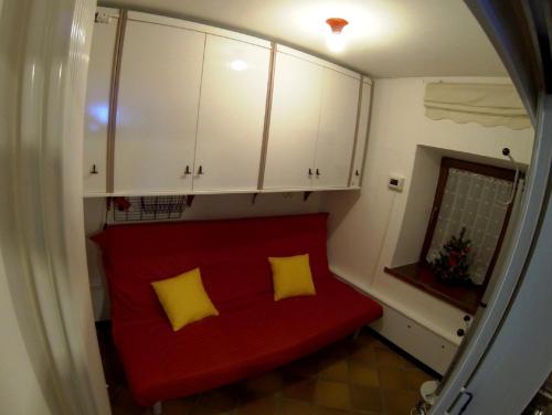 a red couch with two yellow pillows in a room at Dolomites Holidays in Selva di Cadore
