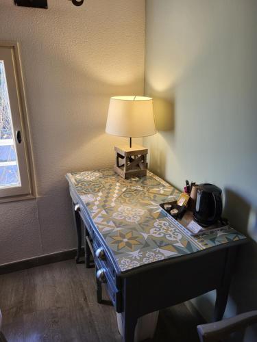 a table with a lamp on top of it at Logis Hotel la Ferme in Avignon