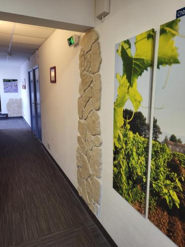 a hallway in a building with paintings on the wall at Logis Hotel la Ferme in Avignon