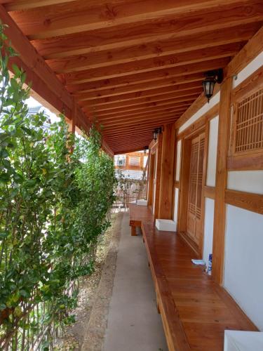 a porch of a house with a wooden roof at Adam Guesthouse in Gyeongju