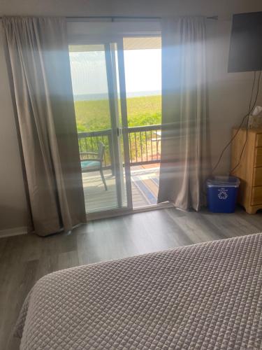 a bedroom with a bed and a view of a balcony at On the Beach Motel in Old Orchard Beach