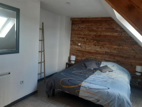 a bedroom with a bed and a brick wall at gîte « Chez Albertine et Thérèse » in Ruffigné